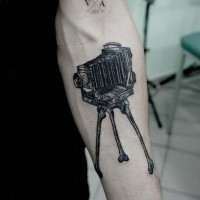 Realistic looking big black ink old camera tattoo on arm