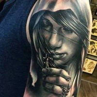 Realistic looking black and white shoulder tattoo of woman with cross