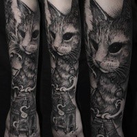 Realistic looking black ink forearm tattoo of cat with old house