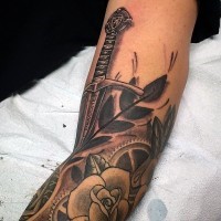 Tatuaje en el antebrazo, espada antigua preciosa y rosas