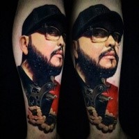 Realistic looking colored arm tattoo of man face with tattoo machine