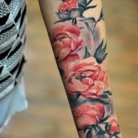 Realistic looking colored forearm tattoo of various flowers