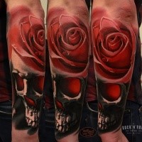 Realistic looking colored hand tattoo of human skull with rose
