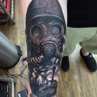 Realistic looking military soldier in gas mask with tank tattoo on arm