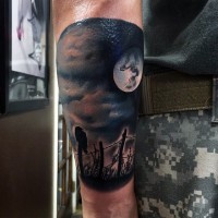 Realistic photo like colored crow on fence with moon tattoo on forearm