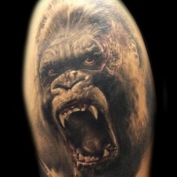 Realistic portrait of an angry gorilla tattoo on shoulder