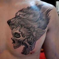 Realistischer Schädel im Rachen des Wolfes Tattoo an der Brust