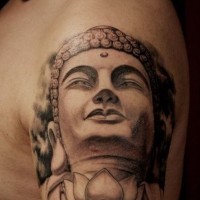 Realistic stone buddha head with lotus tattoo on shoulder