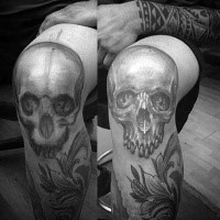 Realistic style black and white skull tattoo on knee