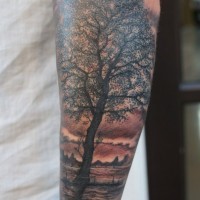 Tatuaje en el antebrazo,
árbol con paisaje detallado