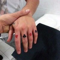 Rote und schwarze Karte kleine Tattoos an Fingern