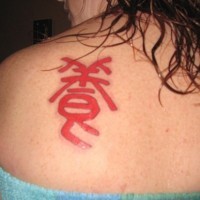 Red chinese character tattoo on scapula