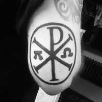 Tatuaje en el antebrazo,
símbolo crismón en círculo, tinta negra