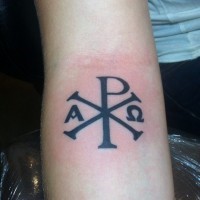 Religious forearm tattoo of Christ monogram Chi Rho in dark black ink