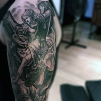 Tatuaje en el hombro, ángel guerrero que mata al demonio, tema religioso