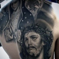 Religious style black and white back tattoo of Jesus and praying woman