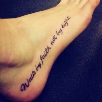 Religious themed lettering foot tattoo in dark black ink