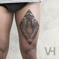 Rhombus like black ink thigh tattoo of symmetrical tiger face by Valentin Hirsch