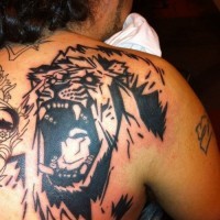 Tatuaggio sulla spalla la faccia di leone con la bocca spalancata