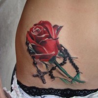 Tatuaje en su estómago, rosa y cruz