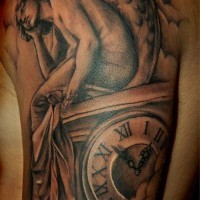 Sad angel and watches tattoo on shoulder