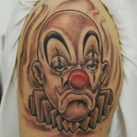 Sad clown with a red nose tattoo on shoulder