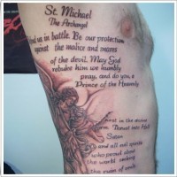 Saint michael and religious text tattoo on ribs