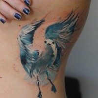 Tatuaje en el costado, gaviota azul vuela
