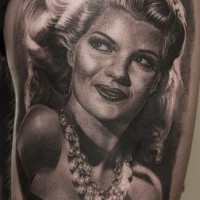 Seductive black and white woman portrait tattoo on thigh