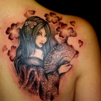 Seductive brunette Asian Geisha with loose hair and hand fen shoulder blade tattoo with floral ornament