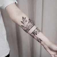 Separated black ink forearm tattoo of wild roses