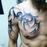 Tatuaje en el brazo y pecho, patrón tribal masivo, tinta negra