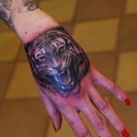 Tatuaje de tigre que ruge en la mano