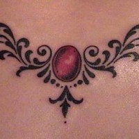 Shipshape tribal tattoo with red gemstone