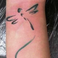 Silhouette of a dragonfly tattoo on wrist