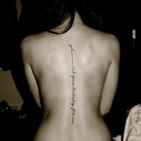 Tatuaje en la columna vertebral, inscripción fina negra