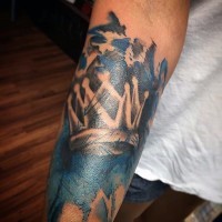 Simple black ink crown tattoo on arm