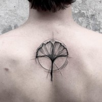 Simple black ink flower shaped black ink tattoo on upper back with circle