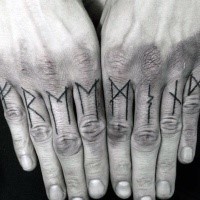 Simple black ink lettering tattoo on fingers