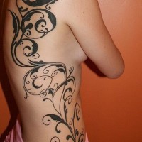 Simple black ink massive floral tattoo on side and thigh