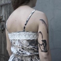 Simple black ink ornament tattoo on shoulder