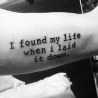 Simple black ink slim lettering tattoo on arm