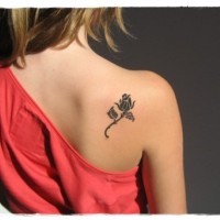 Simple black ink tiny rose tattoo on shoulder