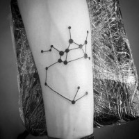 Simple black ink zodiac symbol tattoo on arm