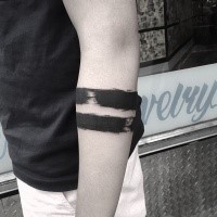Simple blackwork style arm tattoo of ripped black line