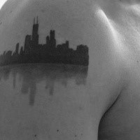 Simple blackwork style small city sights tattoo on shoulder