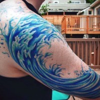 Simple blue colored wave tattoo on shoulder