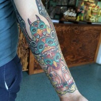 Simple cartoon like colored tribal statue tattoo on arm