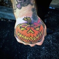 Simple cartoon style designed colored pumpkin tattoo on hand