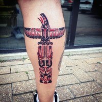 Simple designed and colored big tribal statue tattoo on leg